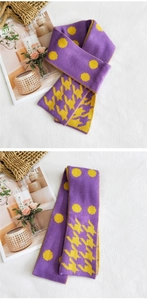 Dettaglio di sciarpa in maglia a pois viola e gialli con trama a pied-de-poule