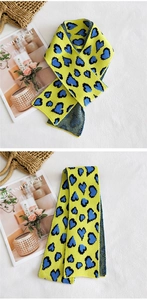 Dettaglio della sciarpa in maglia gialla con motivo leopardato a cuore blu e texture