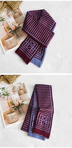 Dettaglio sciarpa in maglia a righe bordeaux e azzurro con motivi geometrici fini
