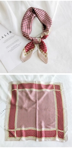 Détail d'un foulard carré en soie avec motif géométrique rouge et beige et fini satiné