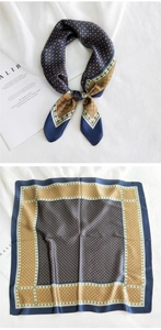 Vue détaillée d'un foulard carré en soie avec motifs géométriques bleu marine et dorés