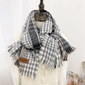 Thick striped scarf with tassels and leather patch on model for winter warmth