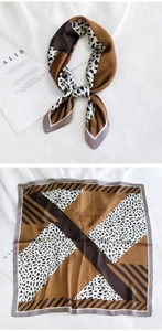Détail d'un foulard carré en soie avec imprimé léopard et motifs géométriques colorés