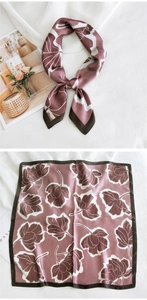 Détail d'un foulard en soie rose avec motifs floraux blancs et bordure marron