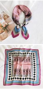 Détail d'un foulard en soie avec motif ananas rose et bordures à rayures géométriques