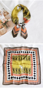 Détail de foulard carré en soie avec motifs d'ananas tropicaux et fini jaune moutarde