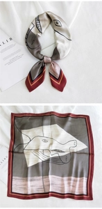 Détail d'un foulard en satin avec imprimé visage abstrait et bordure à rayures rouges