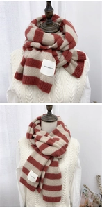 Detail of red-brown and beige striped knit scarf featuring a SEFZ SERVICE woven label tag