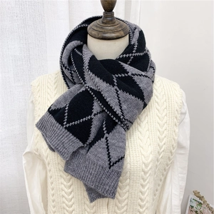 Dettaglio della sciarpa in maglia a rombi con trama reversibile grigio nero e bordo a coste
