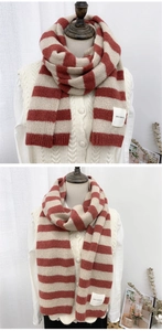 Close-up of red and beige striped knit scarf with textured thick yarn and brand patch