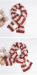 Detail of red and beige striped knit scarf with a woven label on a white background