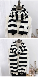 Detail of striped knitted scarf featuring a premium woven texture and decorative fabric label