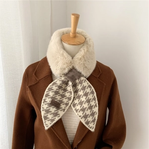 Λεπτομέρεια πλεκτού κασκόλ houndstooth με γούνινη επένδυση και δερμάτινη ετικέτα