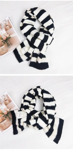 Detail of chunky black and white striped knit scarf with decorative woven label