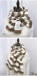 Detail of striped knit scarf showing textured stitch and square woven service label