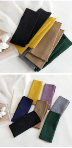 Close-up of ribbed knit arm warmers in various colors featuring subtle sequin details