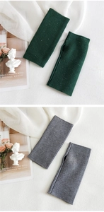 Close-up of knit fingerless gloves in dark green and grey with subtle sequin details
