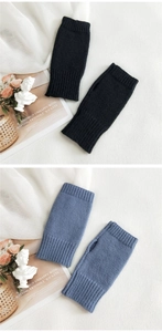 Detail of black and blue knitted fingerless gloves showing elastic ribbed cuffs and texture