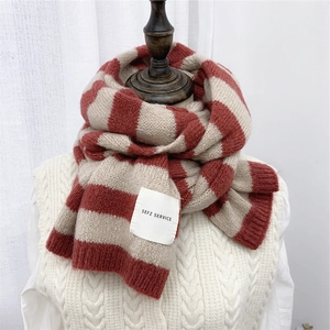Thick red and beige striped knit scarf for women on a mannequin with SEFZ logo tag
