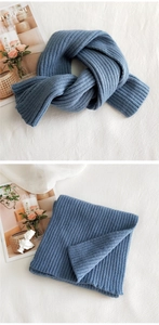 Detail of blue chunky ribbed knit scarf showing thick wool texture and neat weave pattern