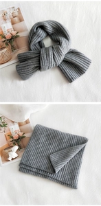 Detail of grey chunky ribbed knit scarf showing thick texture and soft warm material