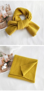 Detail of mustard yellow ribbed knit scarf showing bow-tie style and folded texture