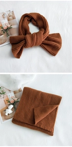 Detailed view of thick caramel knit scarf with vertical stripes and warm texture
