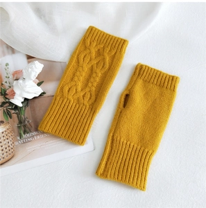 Close-up of yellow knit fingerless gloves with cable knit patterns and ribbed cuffs