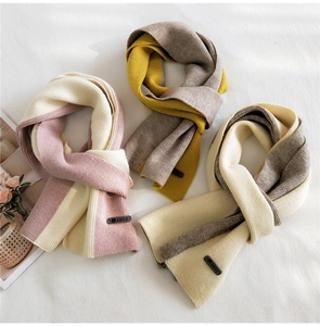 Detail showing two-tone knitted scarf textures with AMILE leather labels on fabric