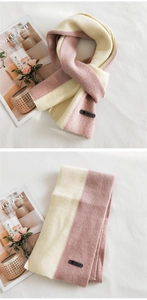 Detail of pink and beige two-tone knitted scarf with brand leather label and thick texture