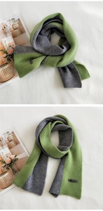 Detail of green and grey knitted scarf showing ribbed texture and black brand label