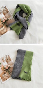 Detail of color-block knit scarf in grey and green with a premium leather logo patch