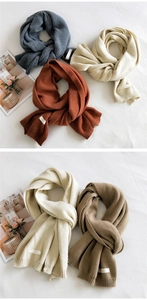 Detail showing soft knitted texture and minimalist white woven labels on colorful scarves
