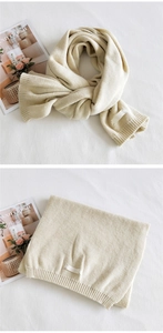 Detail of chunky knit texture and woven label on a beige warm winter scarf