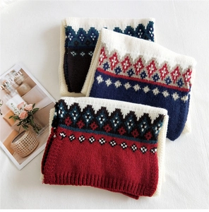 Close-up of thick knitted scarves with vintage ethnic geometric patterns in three colors