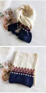 Detail of chunky knit scarf showing Fair Isle geometric pattern and contrast stitching