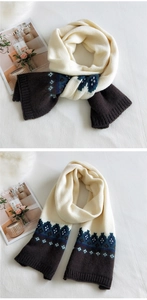 Detailed view of thick cream knit scarf with dark brown and blue-green wave patterns