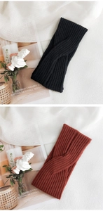 Close-up of knitted twist headbands in black and terracotta on a soft aesthetic background