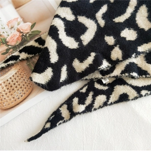 Gros plan sur la texture de l'écharpe en tricot léopard avec tissu pelucheux et carte déco
