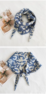 Détail d'une écharpe triangle épaisse en maille avec motif léopard bleu et beige