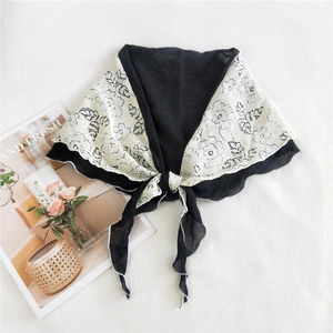 Floral lace triangle scarf in black and beige with wavy edges and stylish magazine background