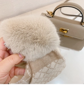 Detail of beige knit scarf with fluffy faux fur trim and elegant quilted texture