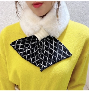 Detail view of winter knitted crossover scarf with white faux fur collar and diamond pattern