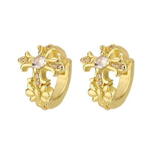 Close-up of gold cross hoop earrings with white zircon inlay and embossed patterns