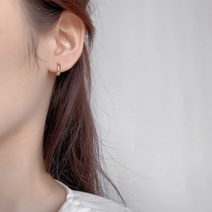 Minimalist textured gold hoop earrings for women showing polished metallic relief design