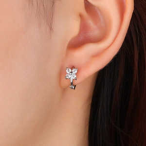 Boucles d'oreilles créoles fleur à quatre pétales en argent portées sur l'oreille