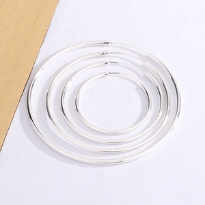 Set of four minimalist silver hoop earrings in varying sizes with a polished mirror finish