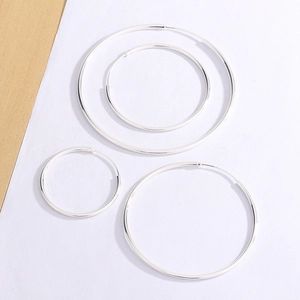 Set of minimalist silver hoop earrings in multiple sizes on a clean white background