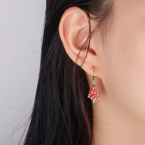 Boucles d'oreilles sapin de Noël en émail rouge avec étoile verte sur modèle