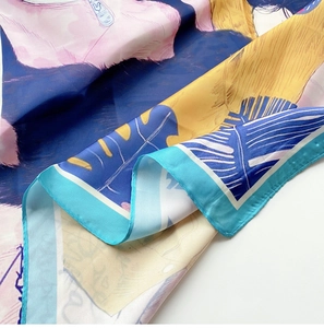 Détail d'un foulard en soie aux motifs tropicaux, bordure roulée et imprimé abstrait